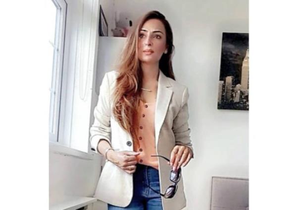 Bushra is pictured wearing a stylish white jacket and jeans, her head and long hair are fully on show
